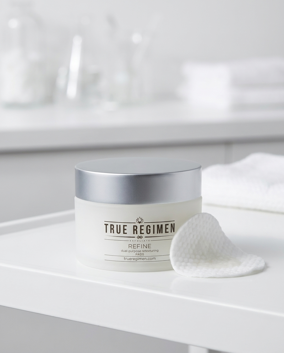 True Regimen Refine Peel Pads styled on a marble vanity in soft window light
